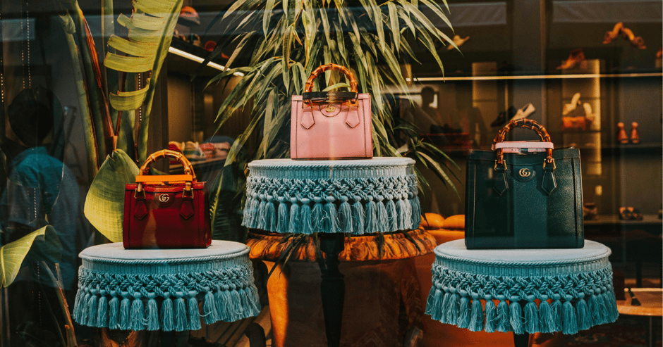 A photo of purses inside of a luxury store window.